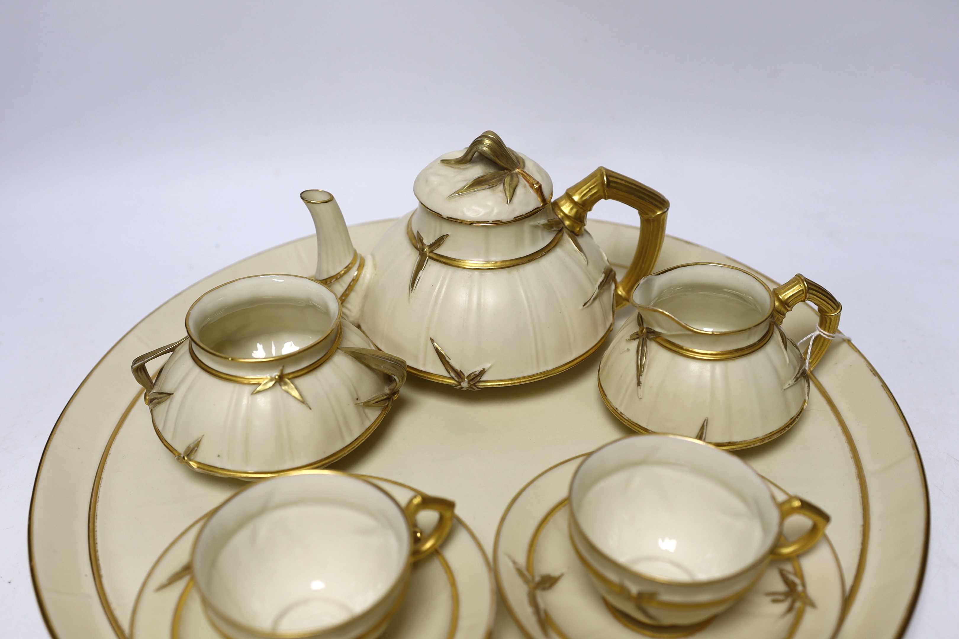 A late 19th century Royal Worcester ivory ground and gilt decorated cabaret set, tray 37cm diameter